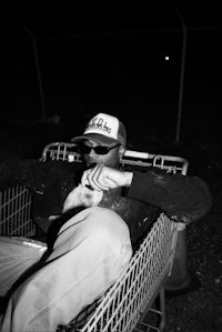 a man sitting in a shopping cart