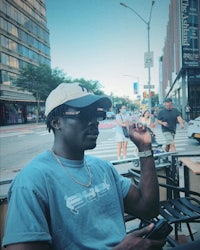 a man sitting on a bench in a city